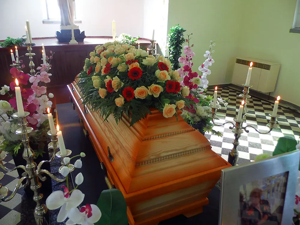 Ein dekorierter Sarg mit Blumen und Kerzen-Arrangement